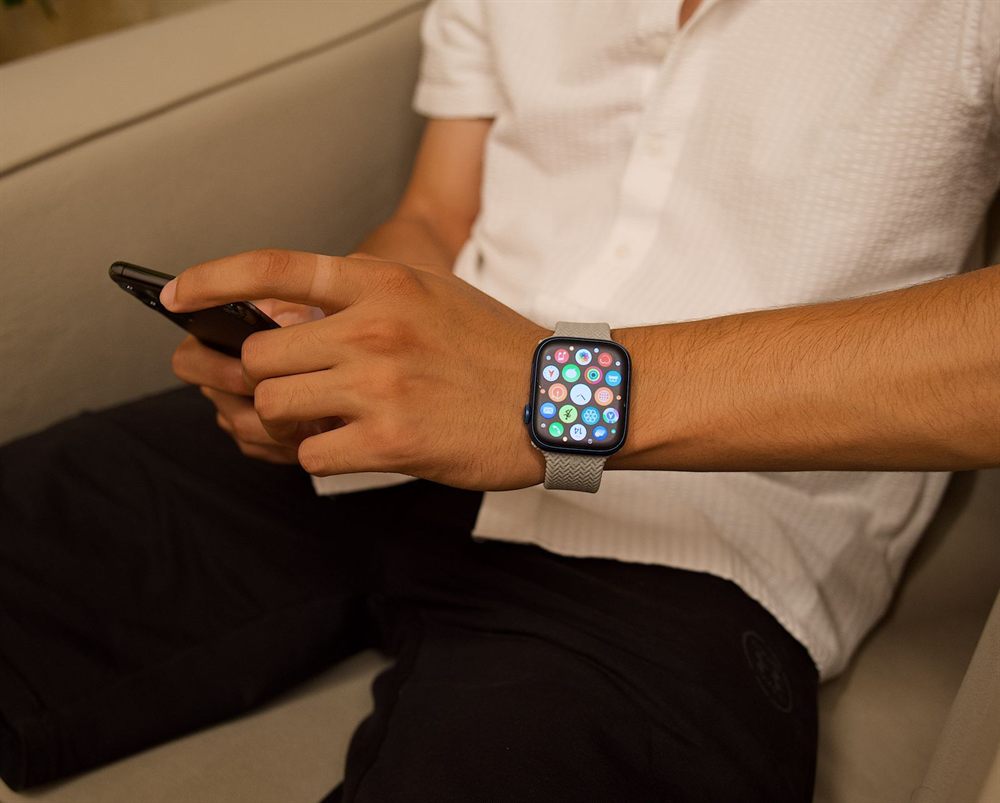 Man using a smartphone while wearing a smartwatch
