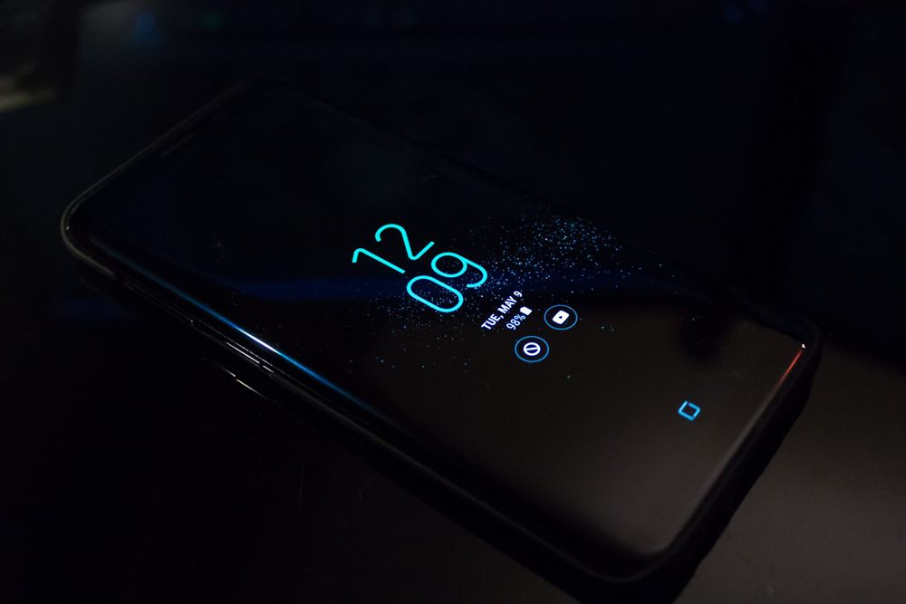Phone lock screen glowing with the time in a dark room